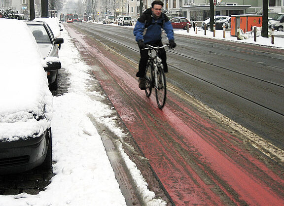 Ein leicht verschneiter Radweg.